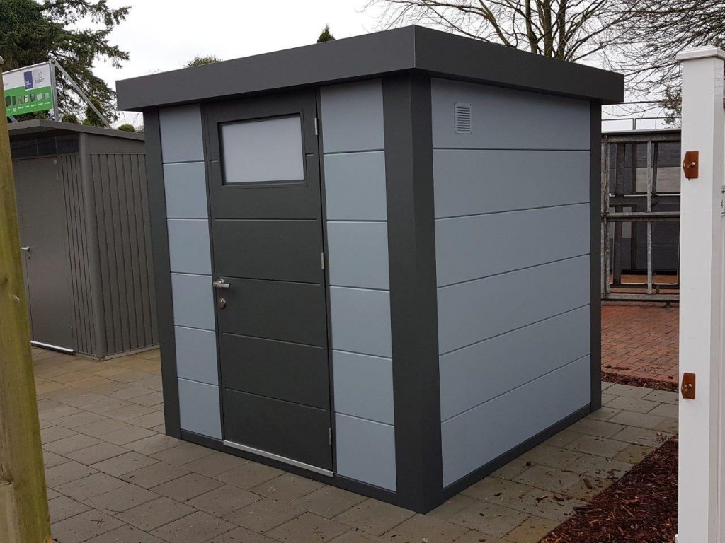 The Telluria Eleganto 2121 metal steel shed store in light grey positioned in a garden.