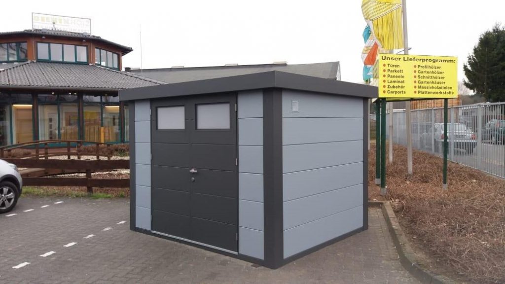 An Angled Photo of The Eleganto 3024 Metal Steel Shed at a College in Light Grey