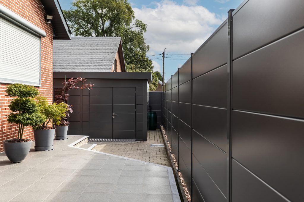 A Photo Of The Eleganto 5435 Metal Steel Building In Anthracite With Optional Solid Doors And Showing Our Metal Fencing System