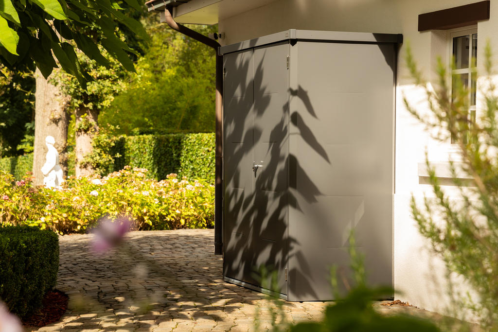 The Telluria Giamadio Garden Cupboard in Anthracite Grey by a house