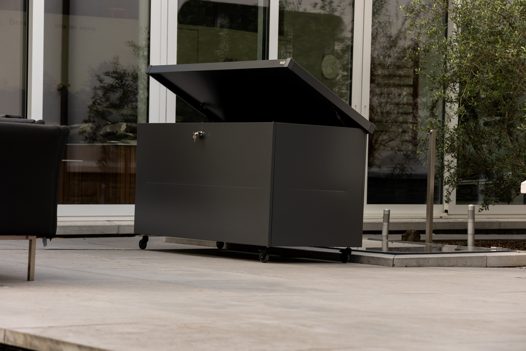 The Telluria Nevio 160 steel garden box in anthracite grey on a patio close up with wheels